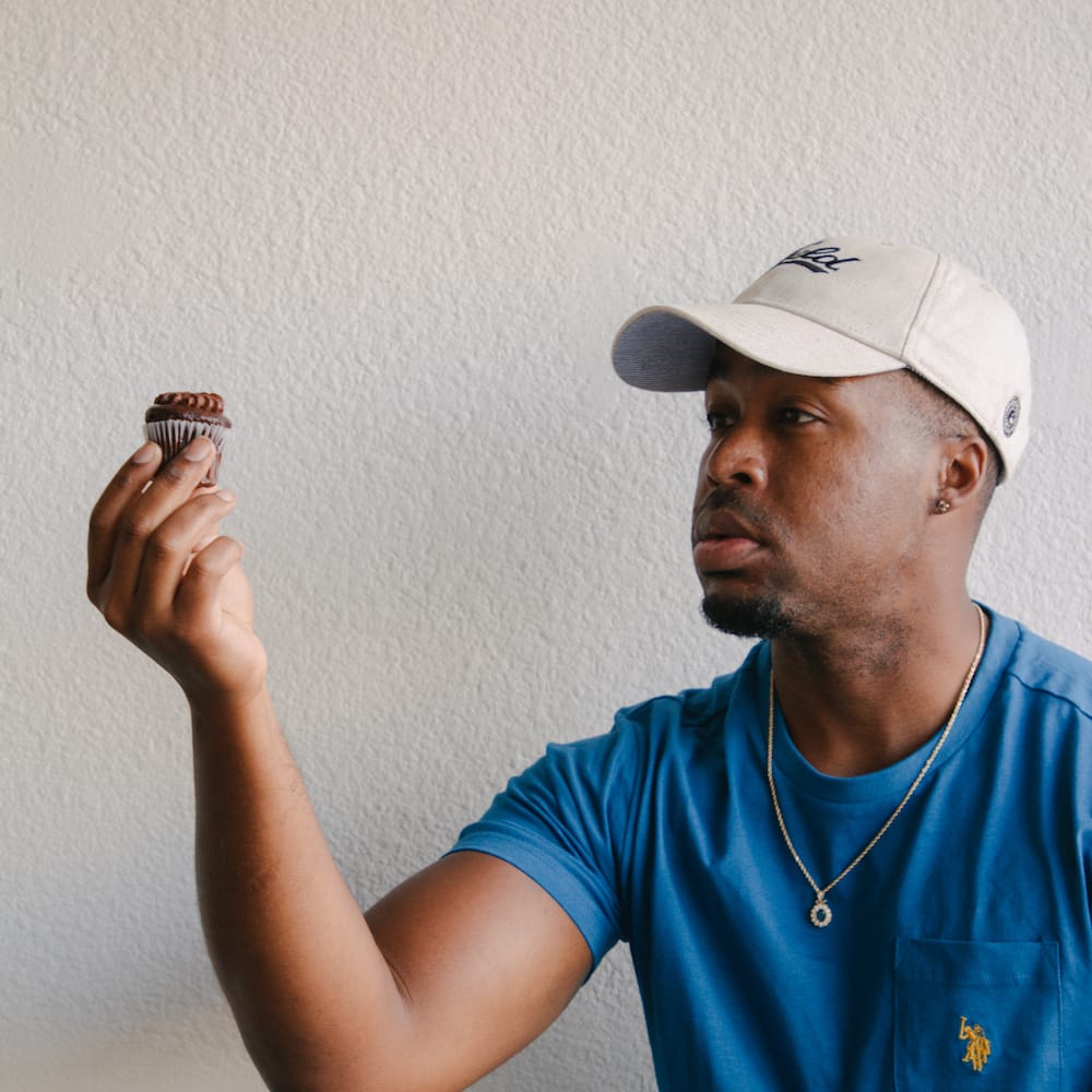 Mike Holding Up A Chocolate Cupcake